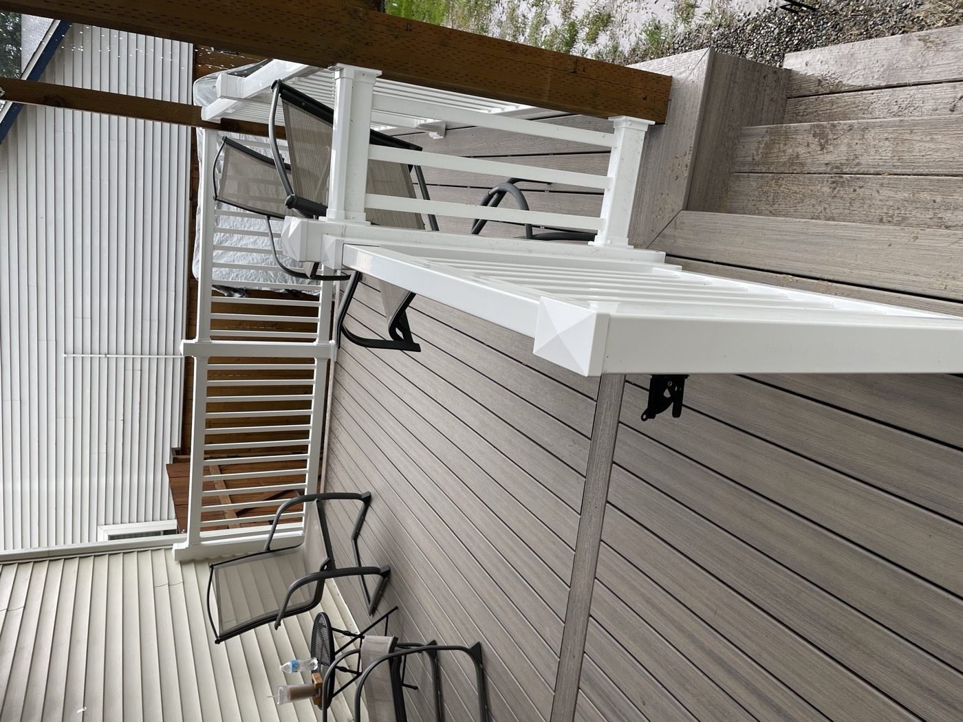 Rebuilt front porch with composite decking and black aluminum railings on a brick ranch home